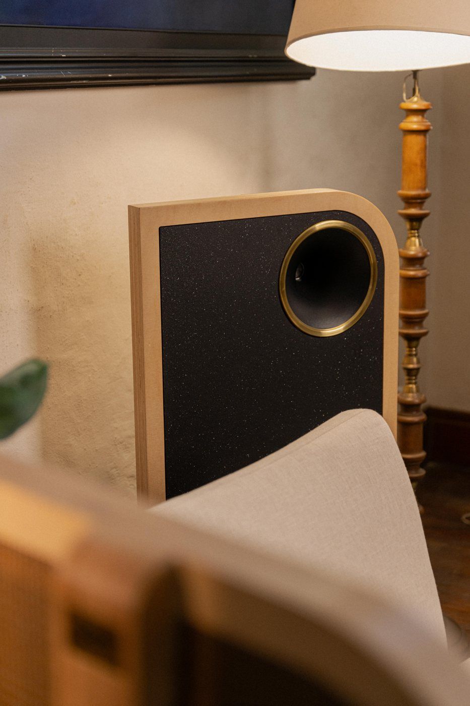 Par de parlantes The Owl a los lados de un mueble con tocadiscos y vinilos, en un living en penumbra