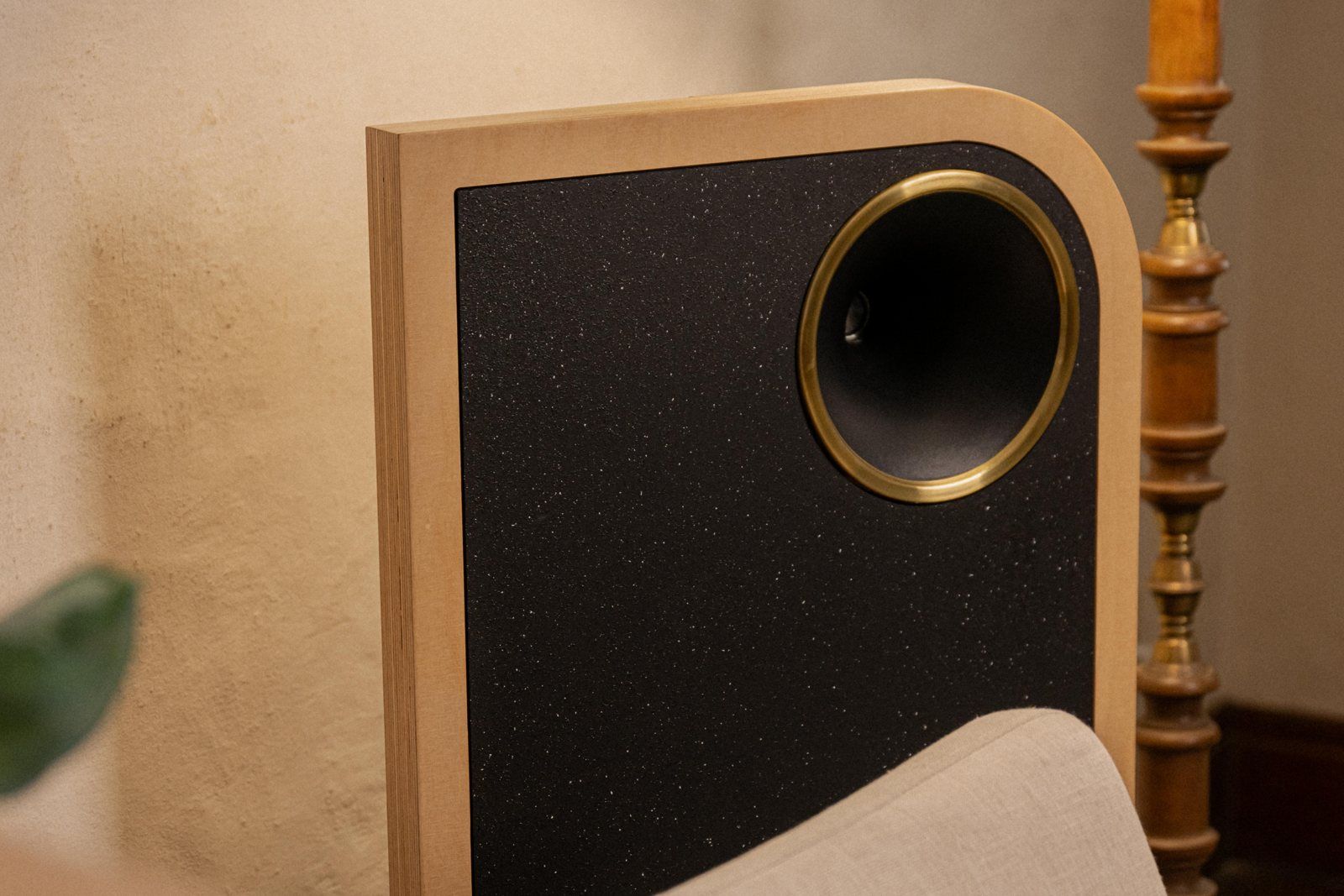 Parlante The Owl en un living, junto a una lámpara de pie